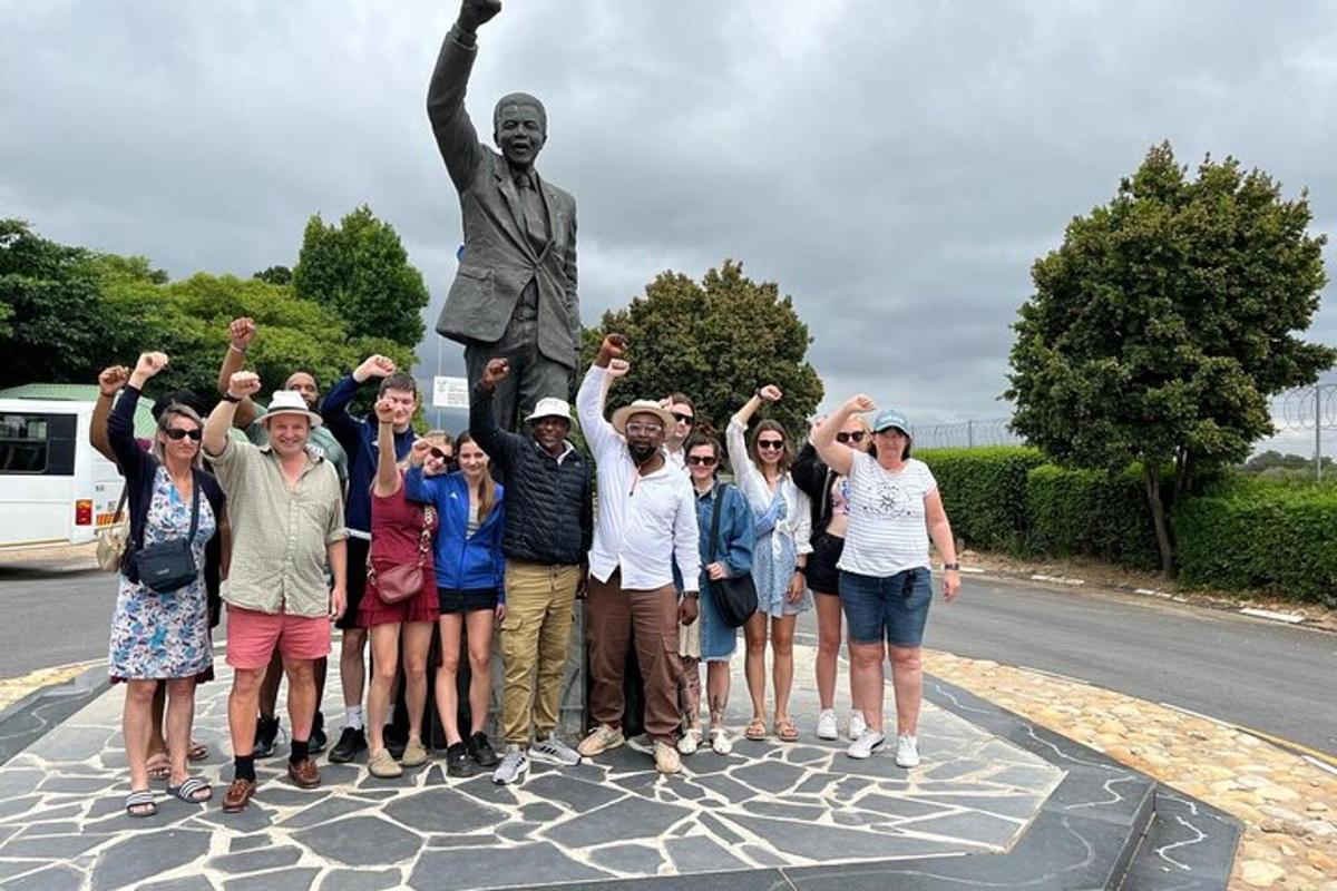 Un grupo de personas de pie frente a una estatua
