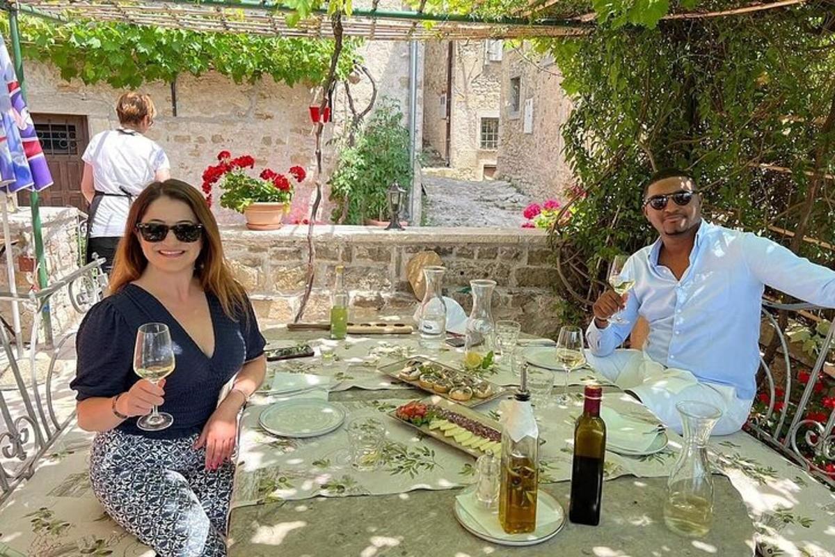 un uomo e una donna seduti a un tavolo con bicchieri di vino