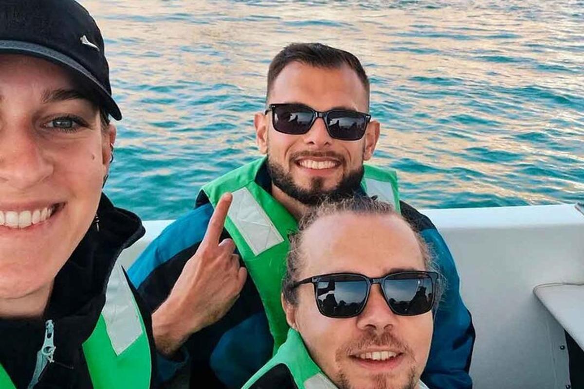 three men in sunglasses on a boat in the water