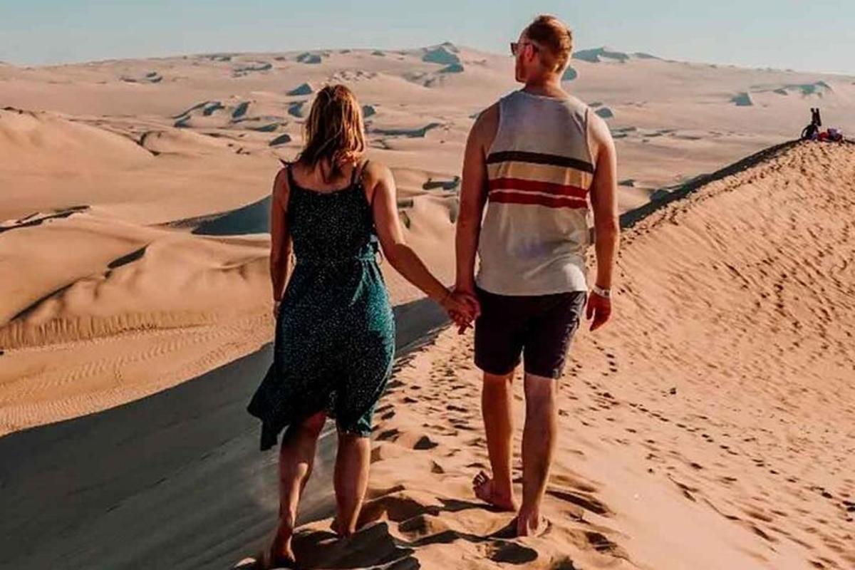 a man and a woman walking in the desert