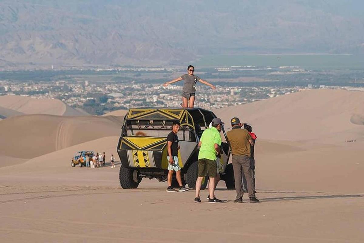 a group of people standing on top of a jeep in the desert