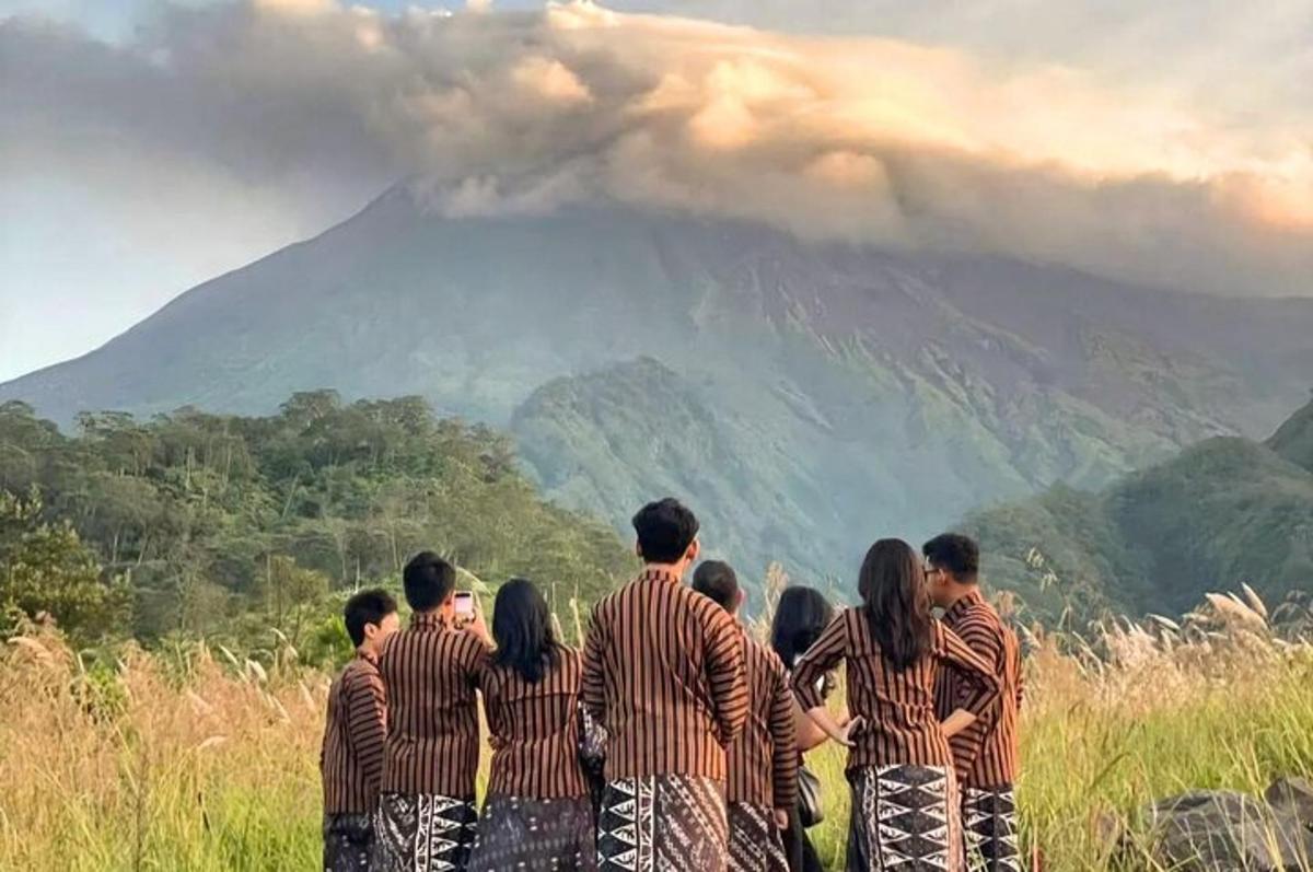 a group of people standing in front of a mountain