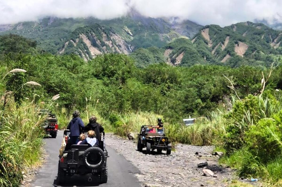 a group of people riding in small cars on a road