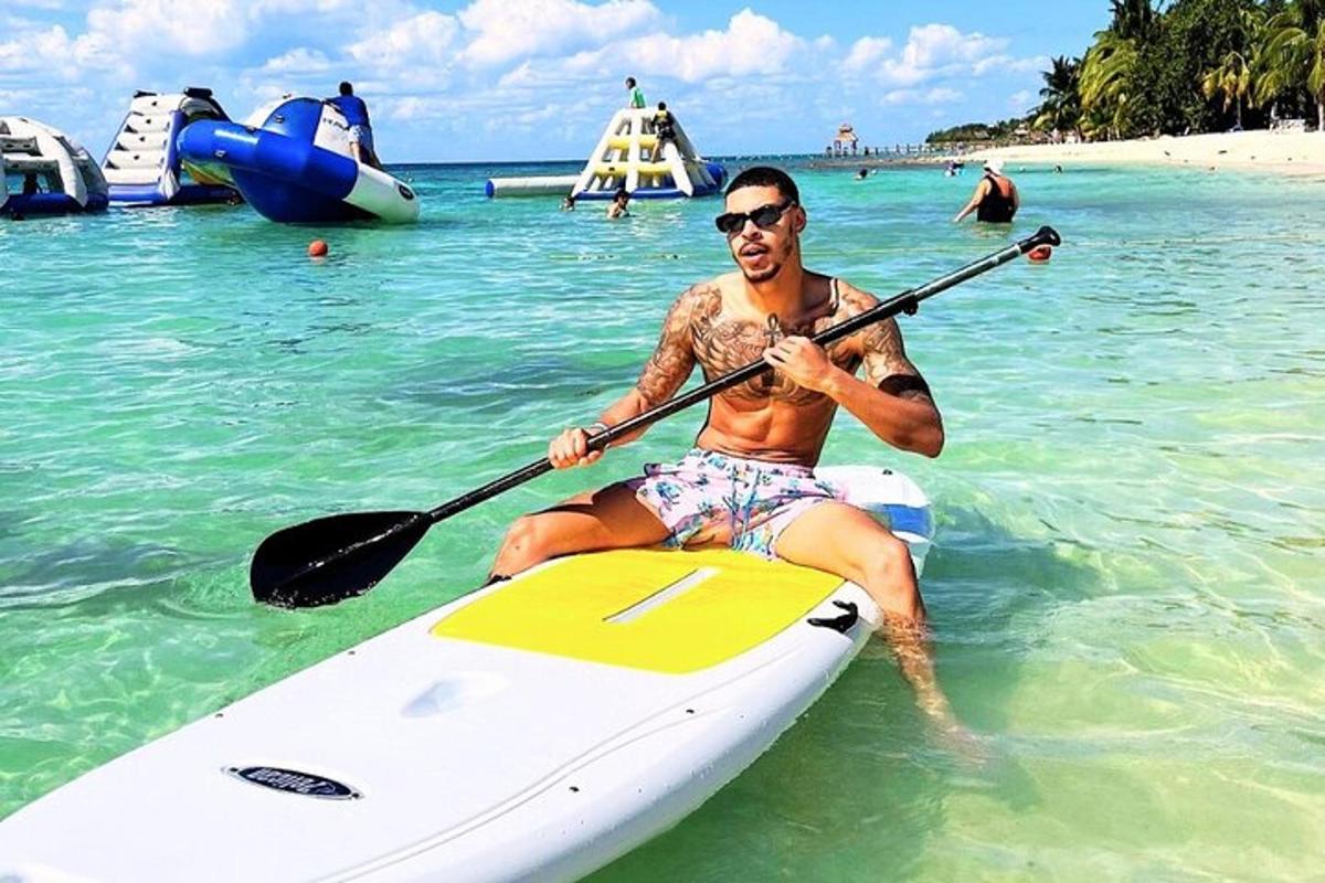 seorang lelaki sedang duduk di atas kayak di lautan