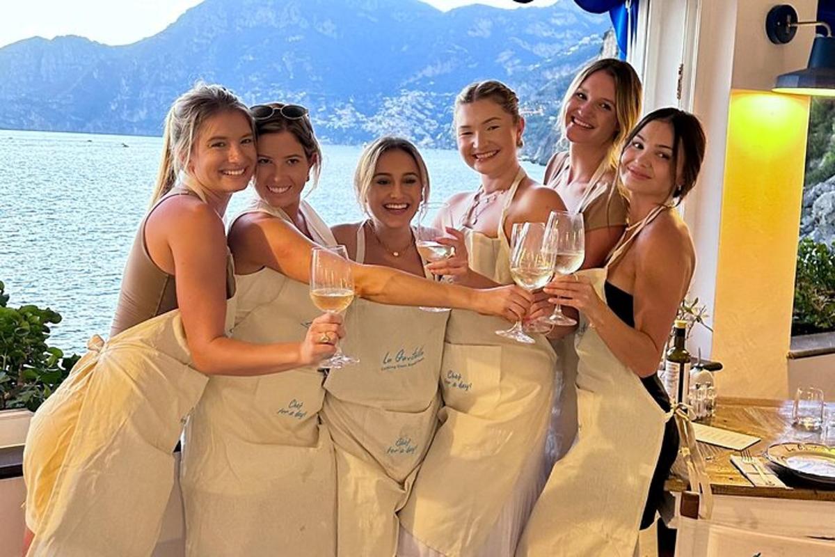 Un grupo de personas vestidas de blanco sosteniendo copas de vino.