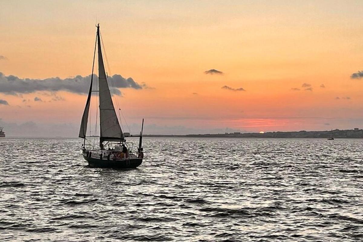 una barca a vela in acqua al tramonto