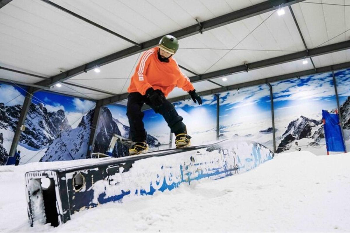 un uomo che fa snowboard su una rotaia nella neve