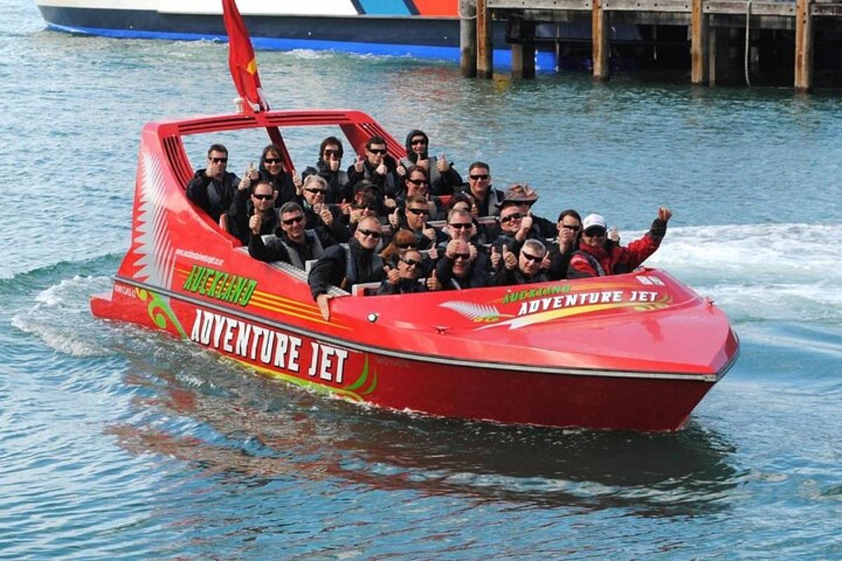 un gruppo di persone su una barca rossa in acqua