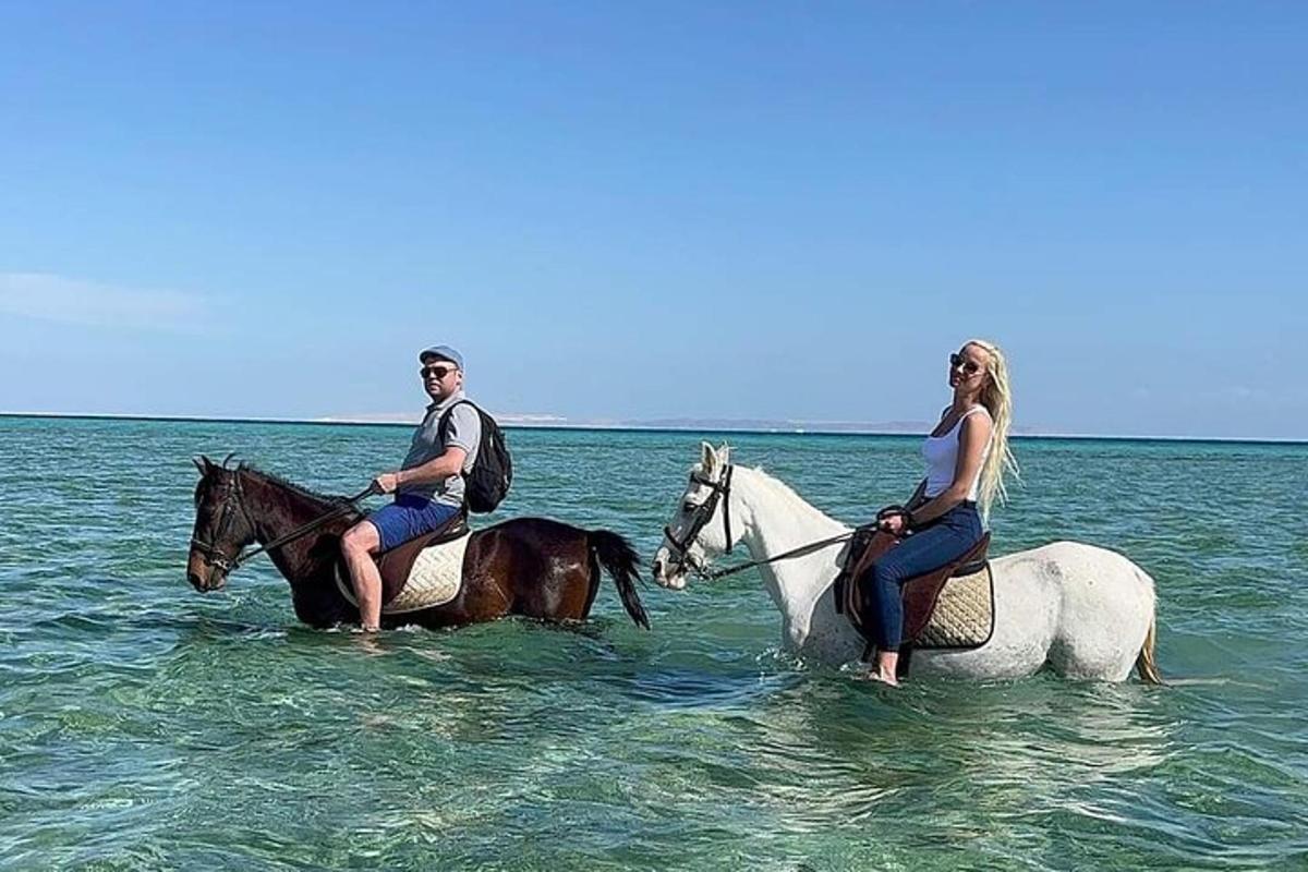 moški in ženska jahata konje v oceanu
