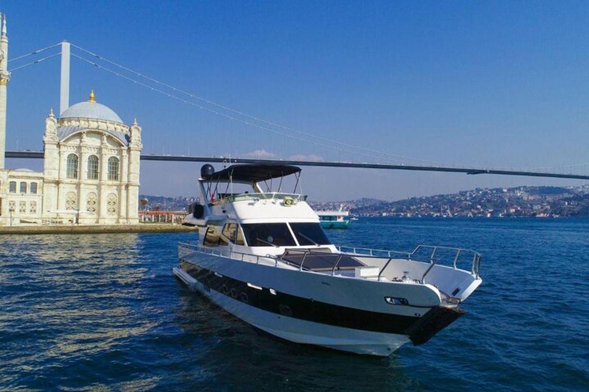 a white boat in the water next to a bridge