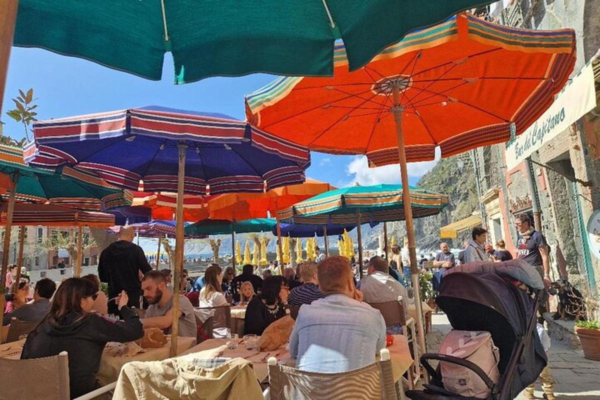 un gruppo di persone sedute ai tavoli sotto gli ombrelloni