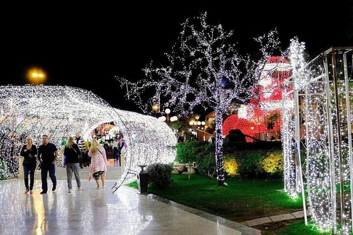 sekumpulan orang berjalan di hadapan lampu krismas