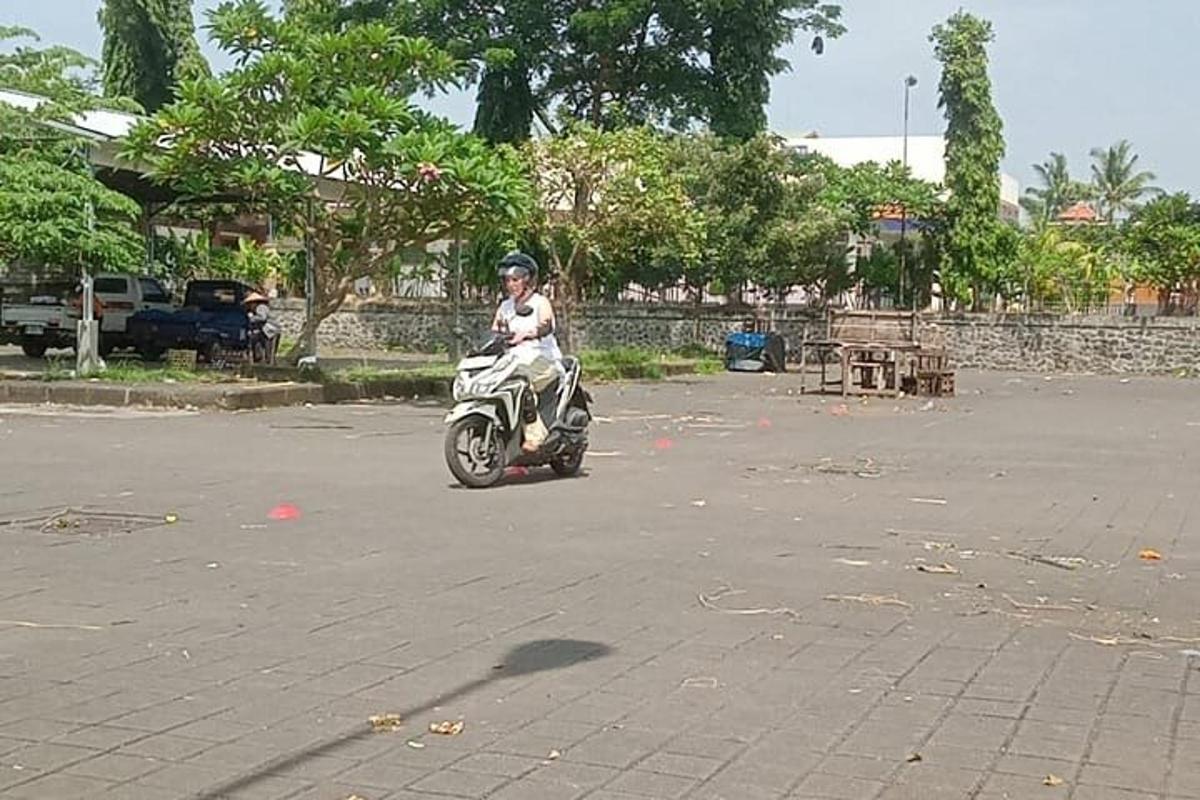 una persona che guida uno scooter lungo una strada