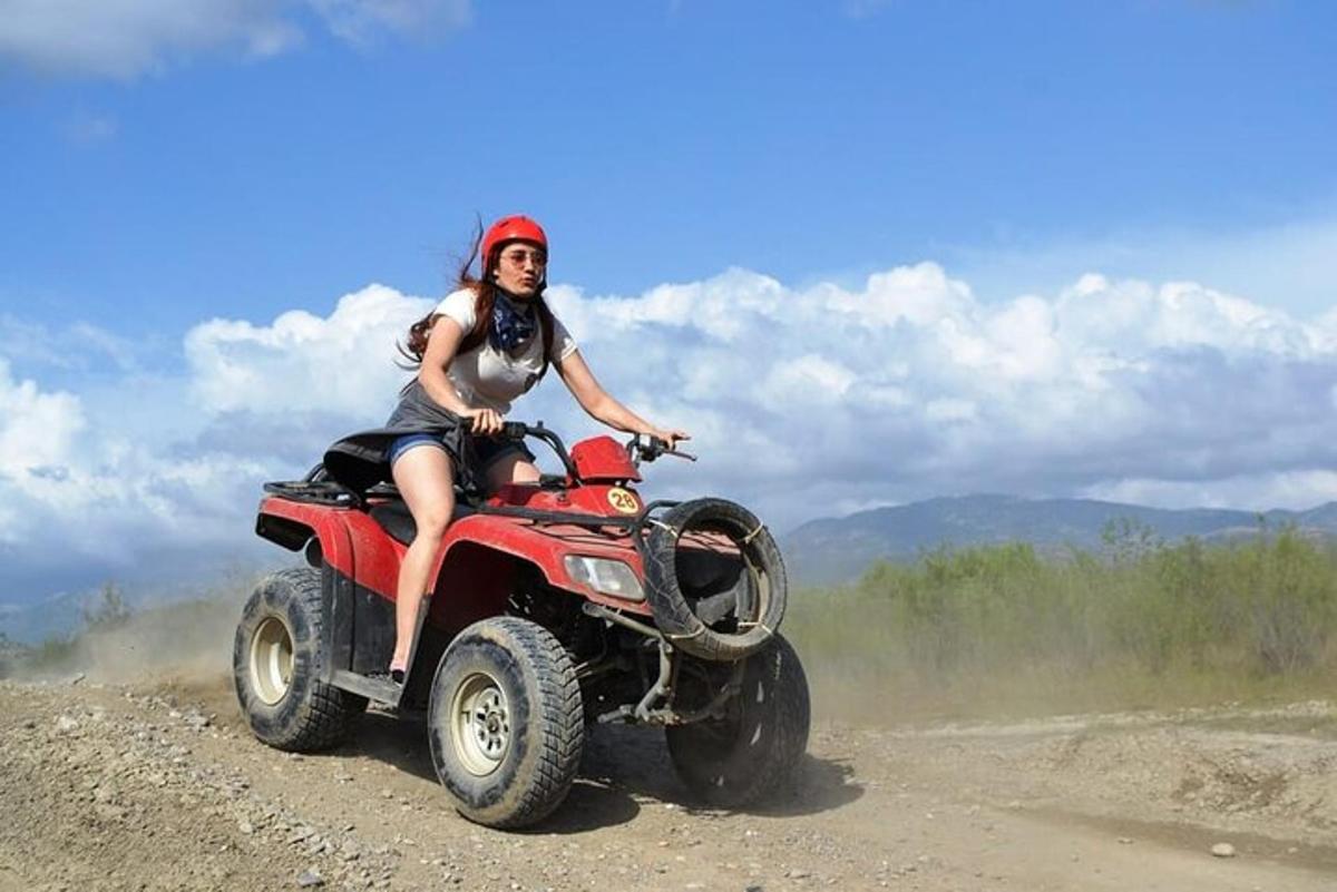 una donna che guida un quad su una strada sterrata