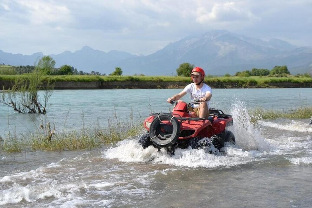 un uomo in sella a un quad in acqua