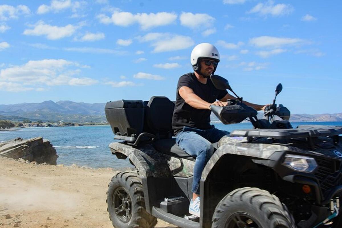 moški sedi na štirikolesniku na plaži