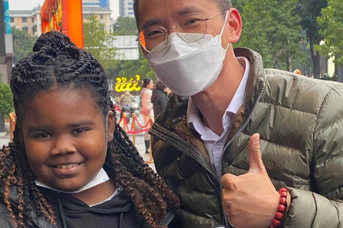 a man wearing a mask and a young girl giving a thumbs up