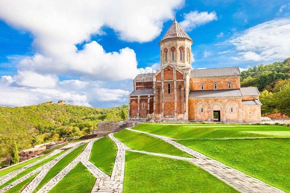 stara opečnata stavba s stolpom na zelenem polju