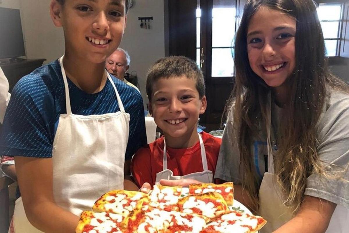 skupina tří lidí držících pizzu
