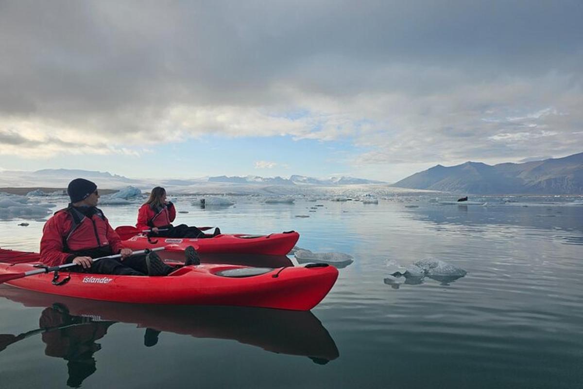 two people sitting in a red kayak on the water
