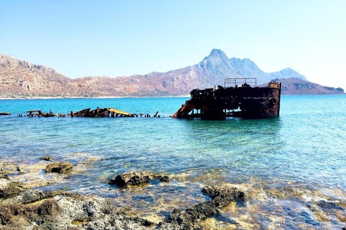Μια παλιά βάρκα στο νερό με βουνά στο φόντο