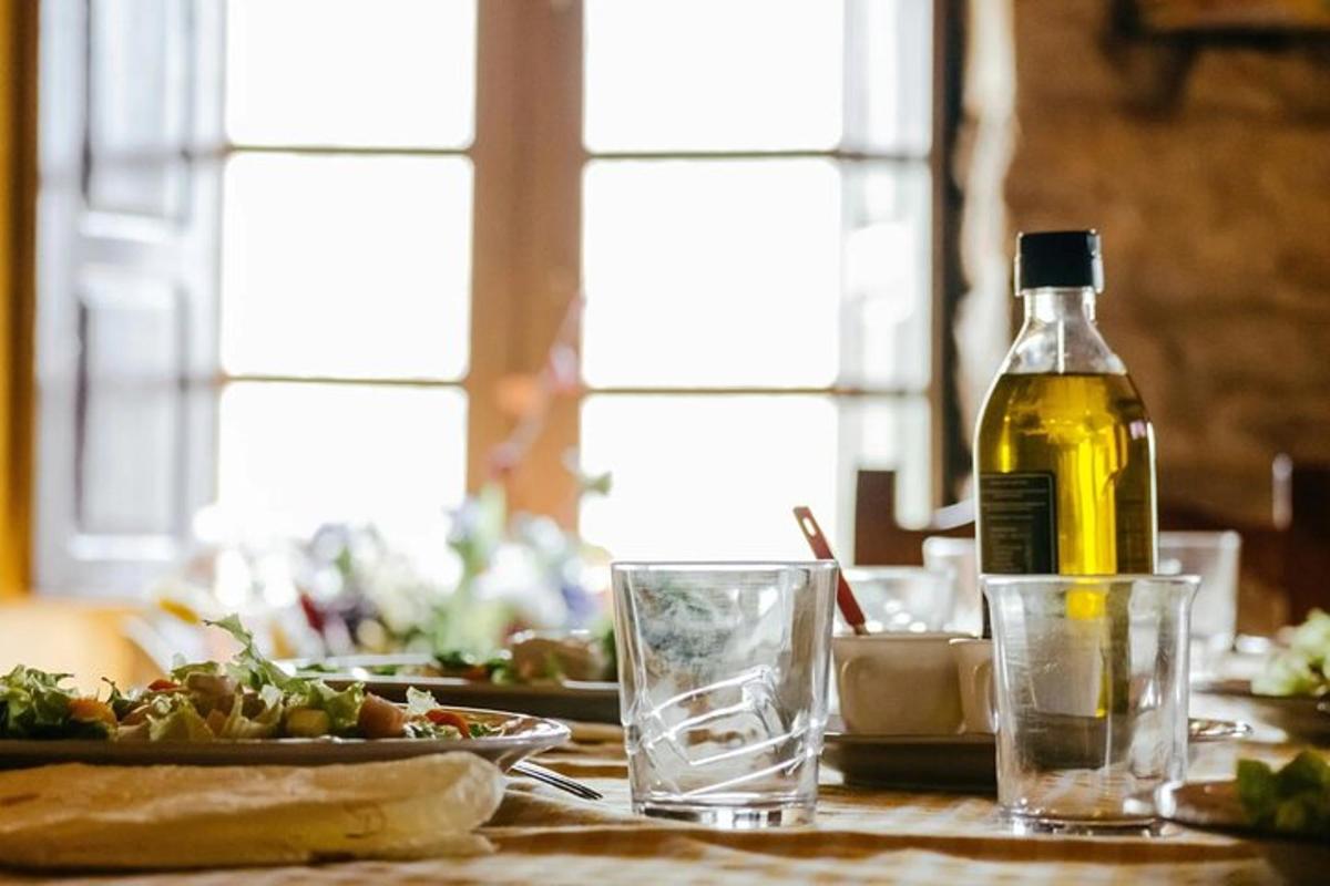 eine Flasche Öl und ein Glas Wasser auf einem Tisch