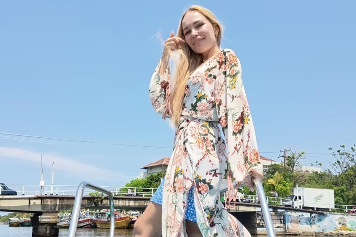 a woman in a floral dress standing on a dock