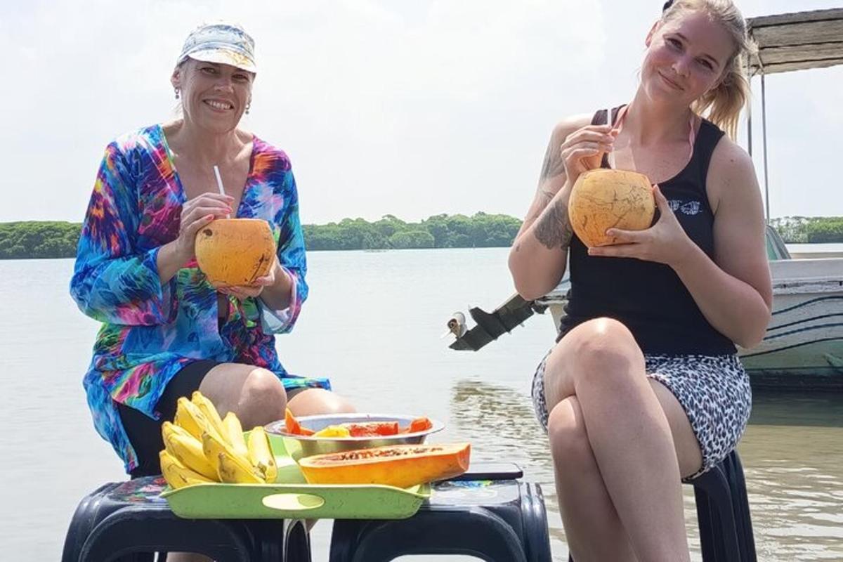 two women sitting on a boat eating food