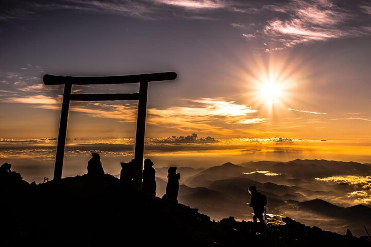 un gruppo di persone in piedi sulla cima di una montagna al tramonto