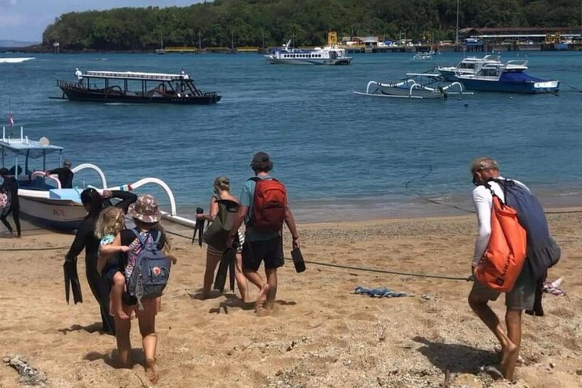 a group of people on a beach with boats