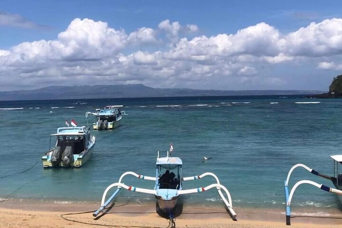 three boats are docked on a beach in the water