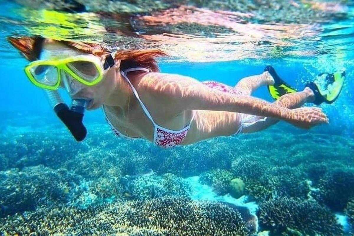 a woman in a swimsuit and goggles swimming in the water