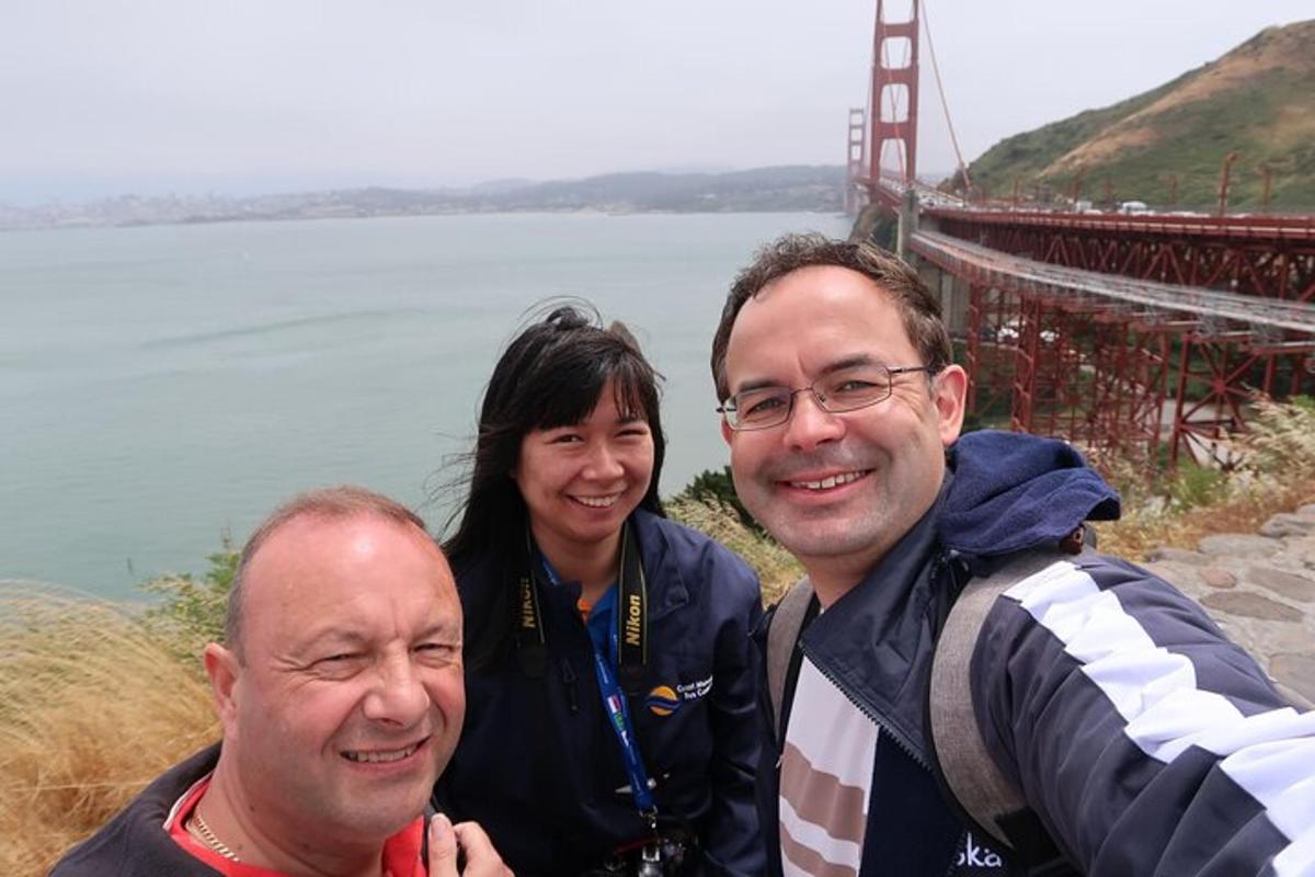 deux hommes et une femme debout devant le pont du Golden Gate
