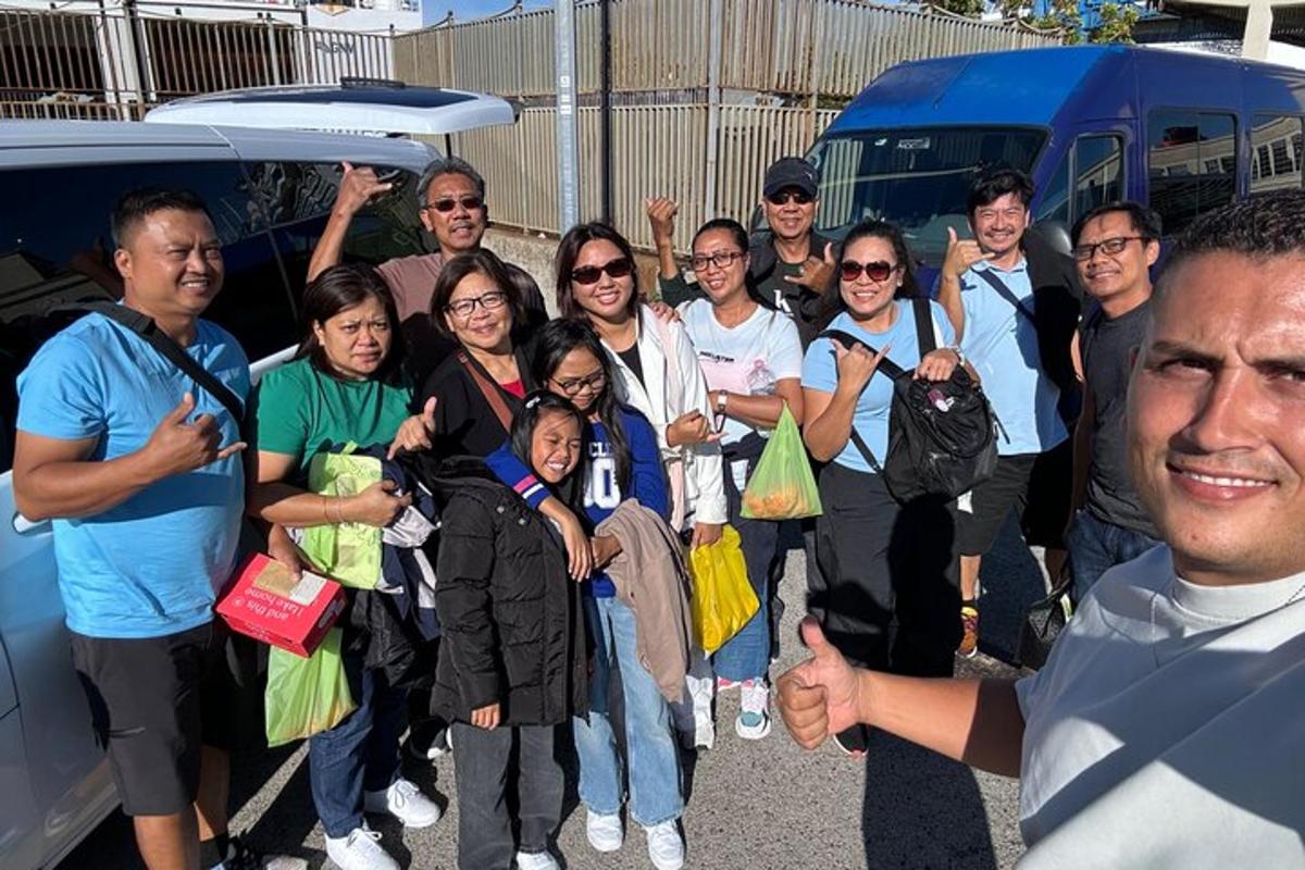 skupina lidí pózujících pro fotografii vedle autobusu