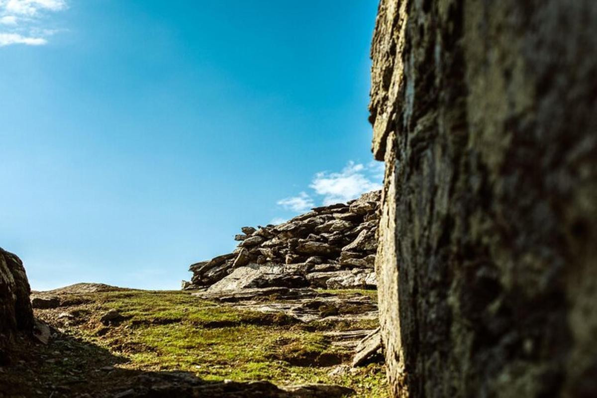 a stone wall on a hill with a blue sky