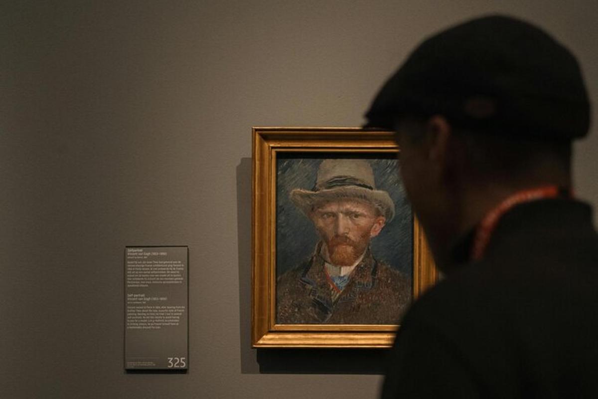 un uomo che guarda un dipinto di un uomo con un cappello