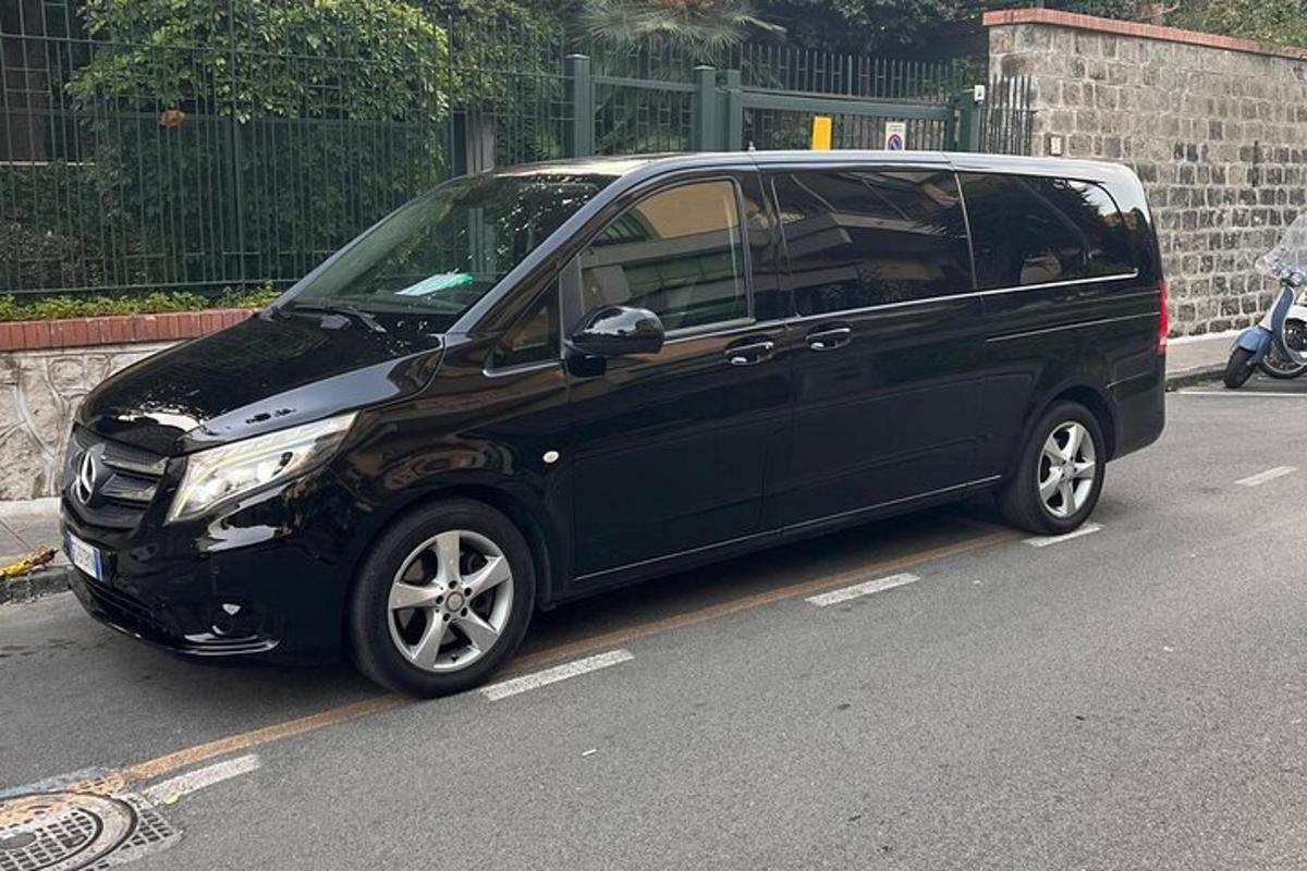 čierna dodávka zaparkovaná na kraji ulice
