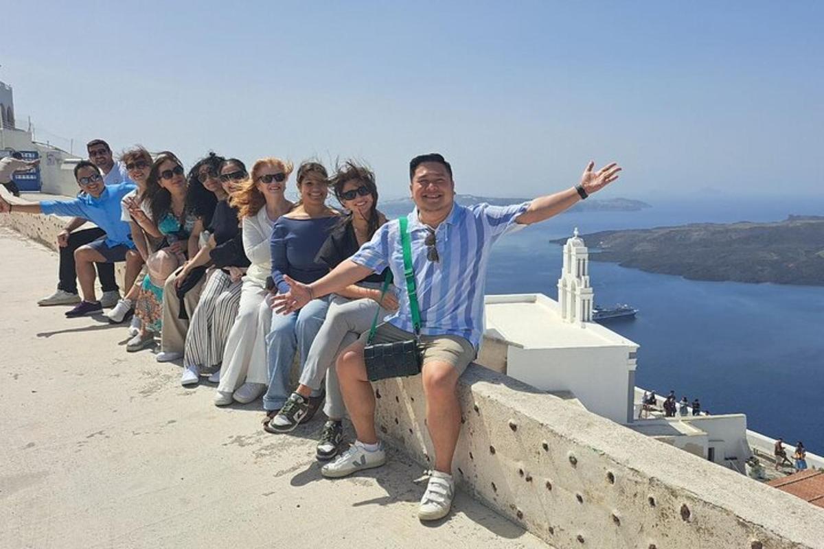 a group of people sitting on top of a wall