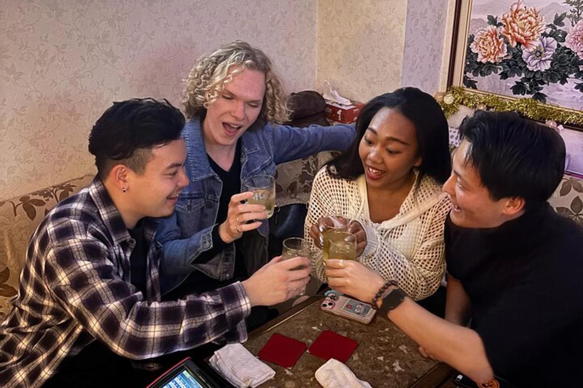 un gruppo di persone sedute attorno a un tavolo con delle bevande