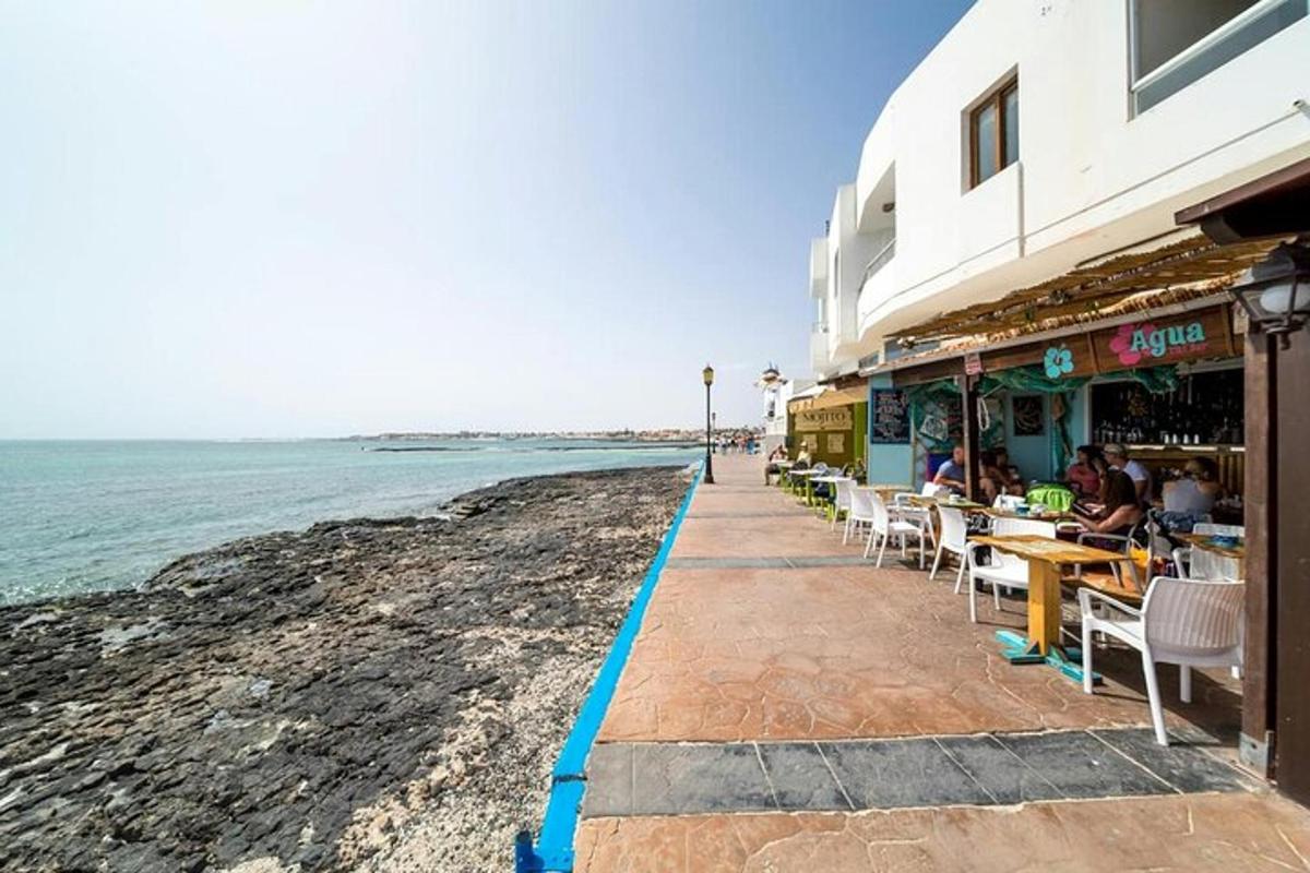 a restaurant on the beach with the ocean in the background