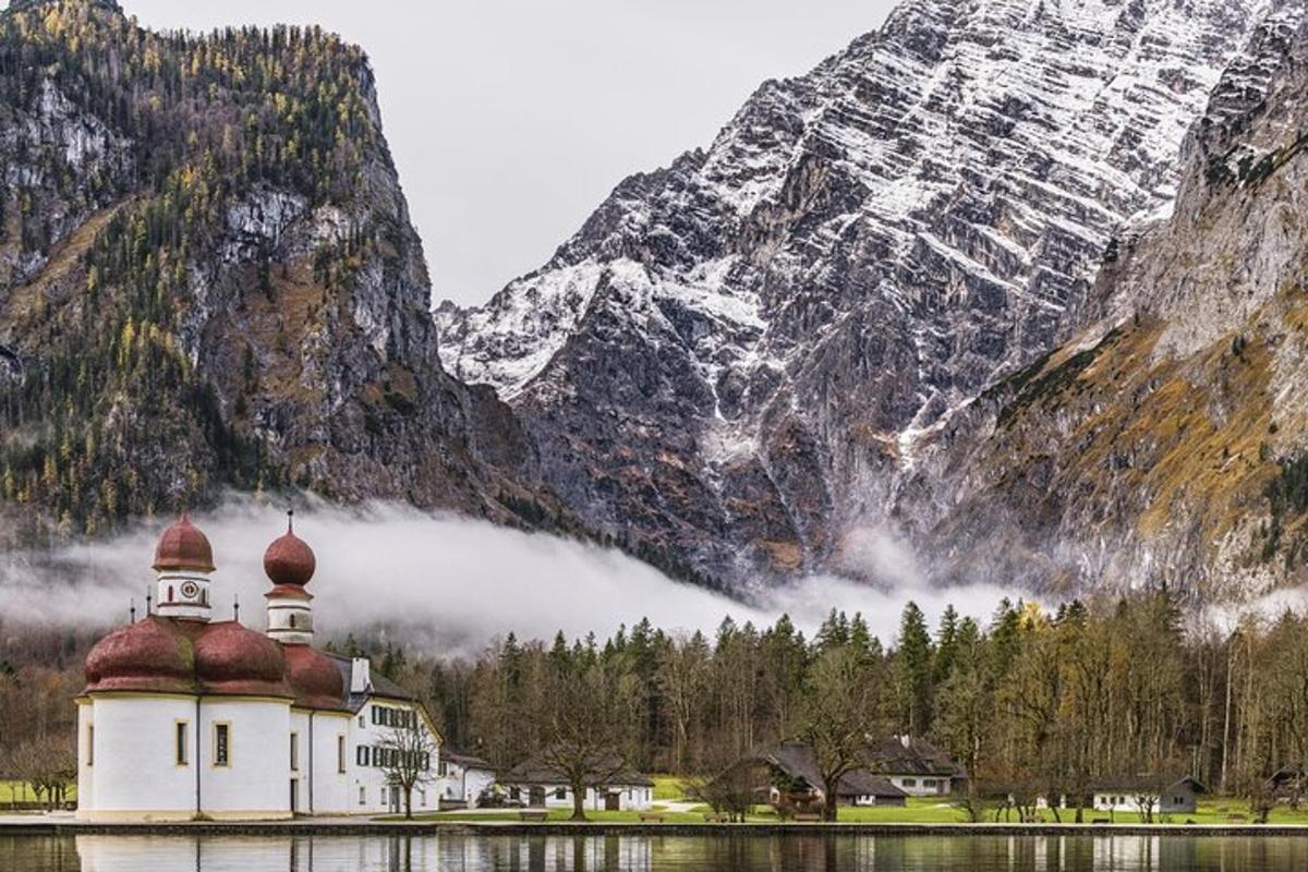 a building on the water in front of a mountain