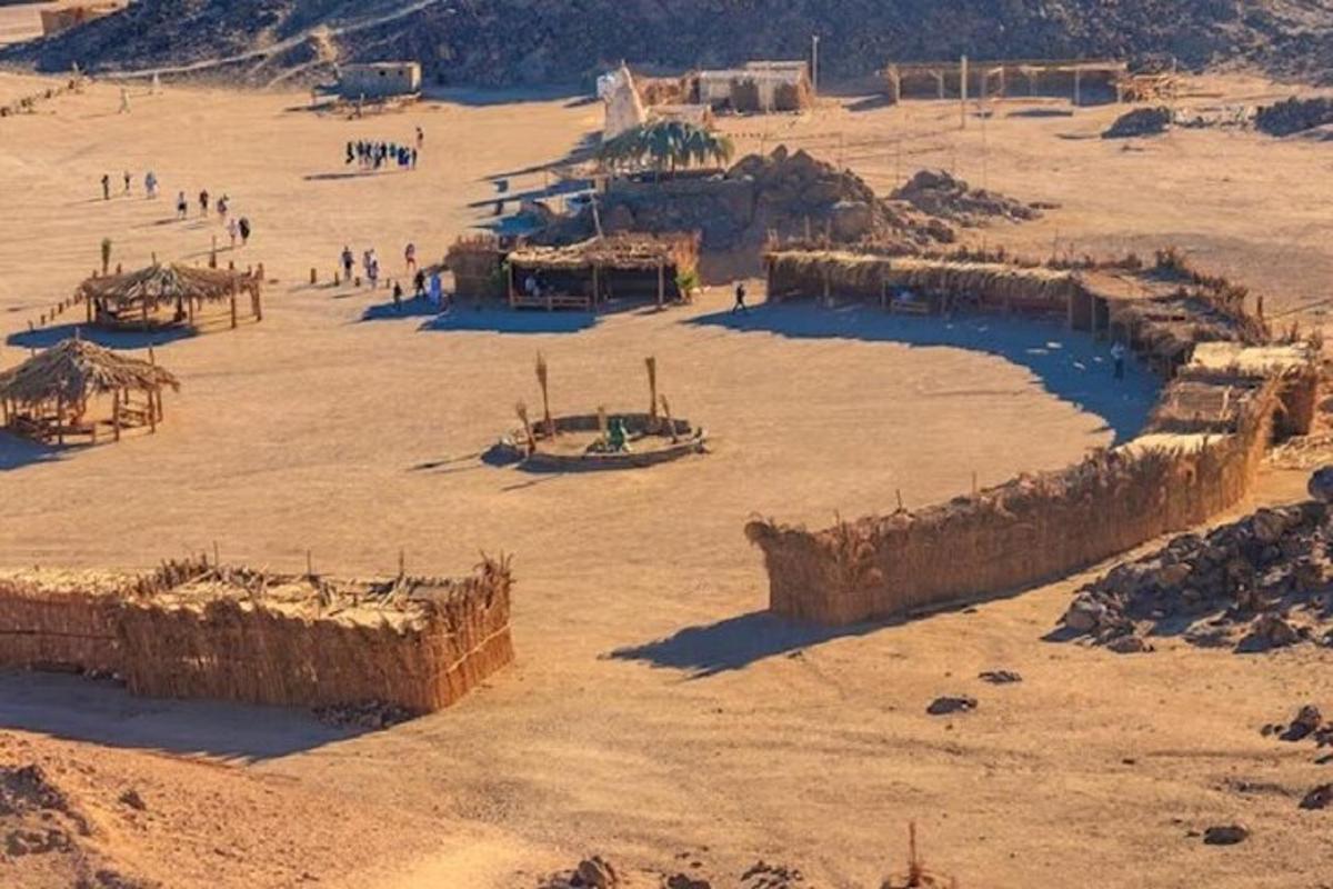 un gruppo di persone in un deserto con edifici di paglia