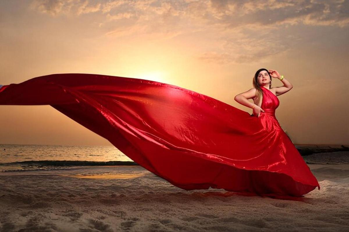 una donna in un vestito rosso sulla spiaggia