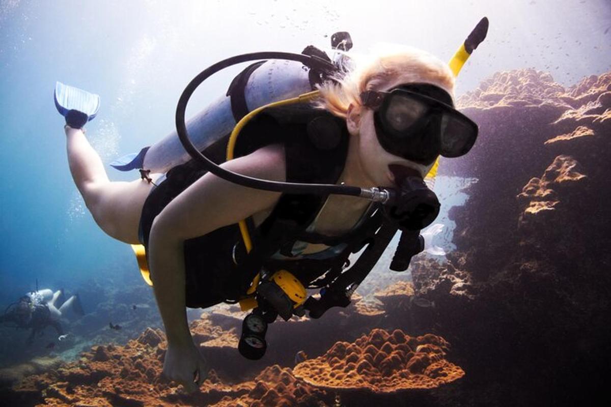 una donna in muta da sub e occhialini che nuota nell'oceano
