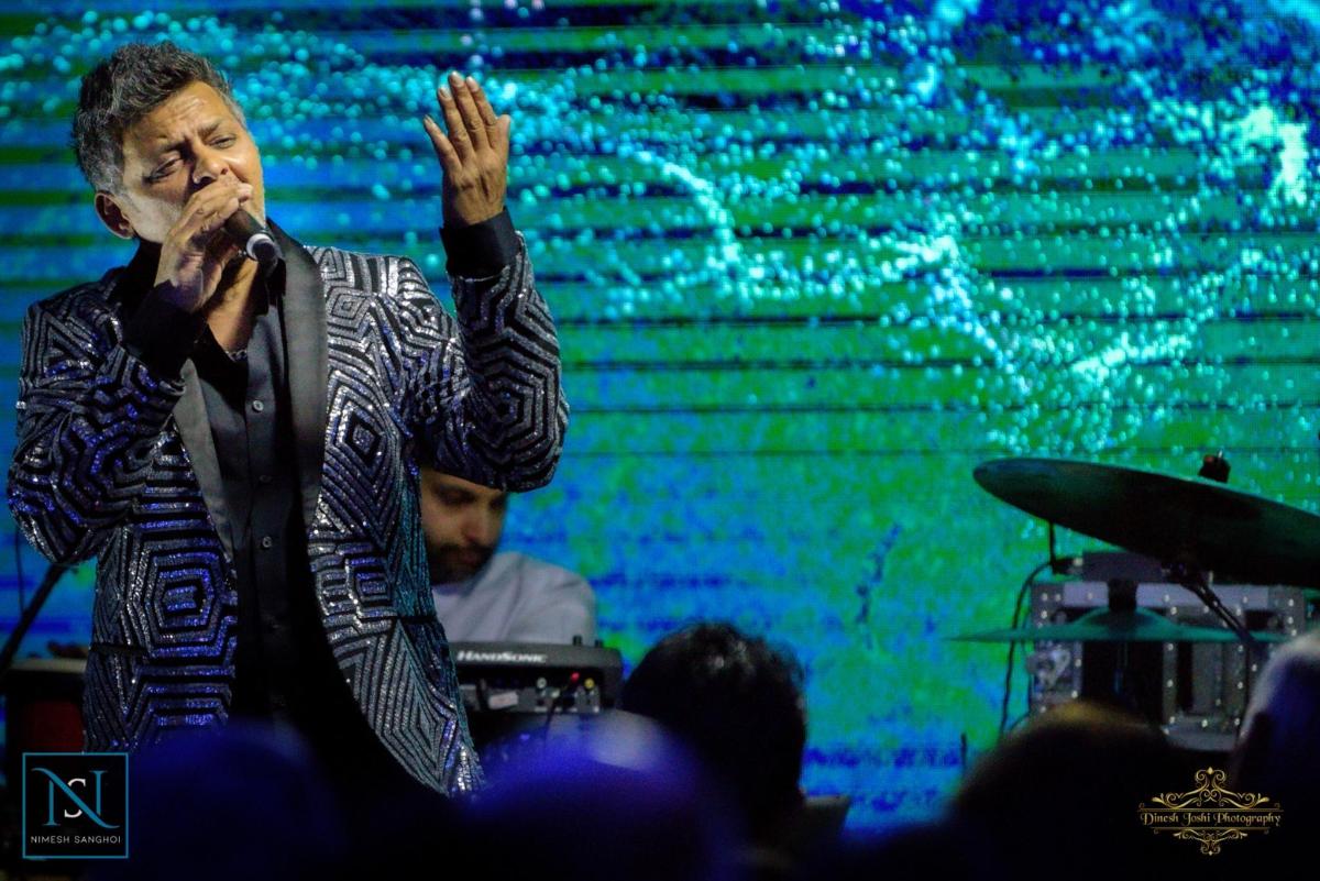 a man singing into a microphone on a stage