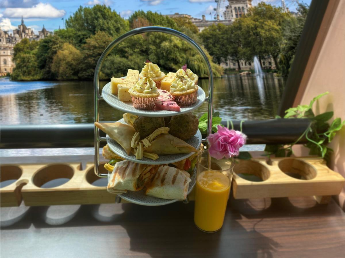 a three tiered tray of pastries and cupcakes on a balcony
