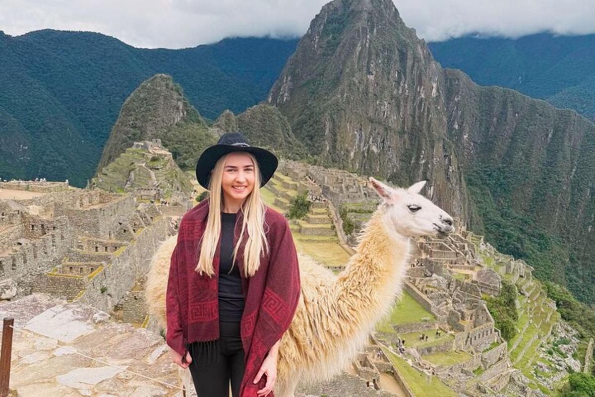 una donna in piedi accanto a un lama su una montagna