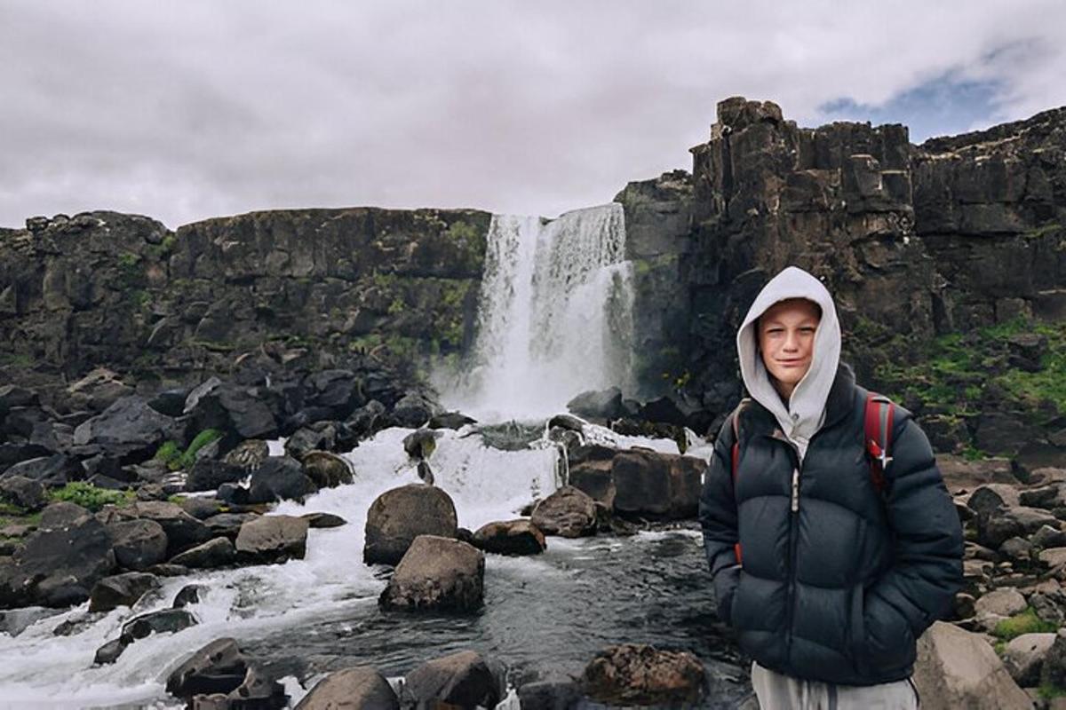 maður stendur fyrir framan foss