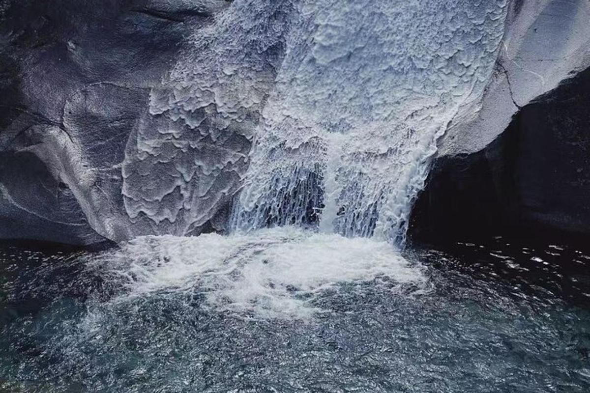 a waterfall with ice on the side of a river