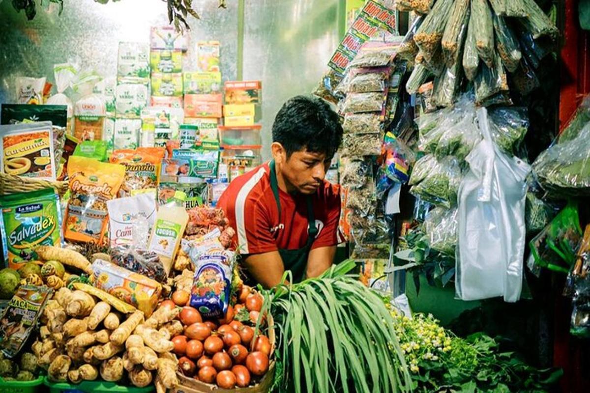 một người đàn ông trong cửa hàng với một đống rau